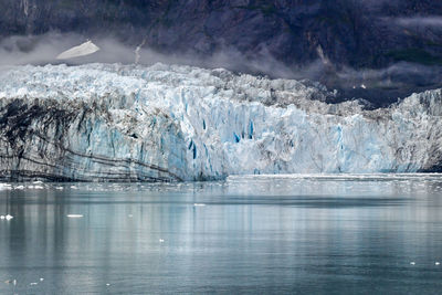 Ancient glacier and foggy dramatic sky in alaska ocean bay