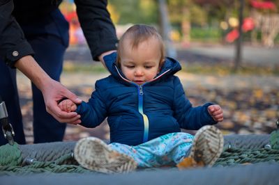 Midsection of father playing with his cute little boy on playground