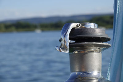 Close-up of metal railing on sailboat by sea against sky
