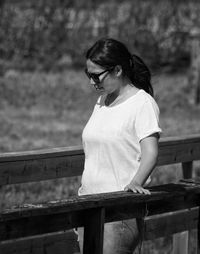 Woman looking away while standing at footbridge