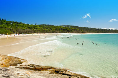 Scenic view of beach against blue sky