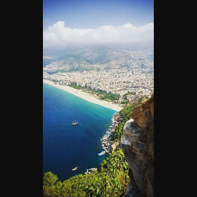 sea, water, aerial view, sky, high angle view, horizon over water, coastline, cityscape, scenics, city, nature, ocean, beauty in nature, built structure, transportation, mountain, blue, tranquil scene, tranquility, architecture