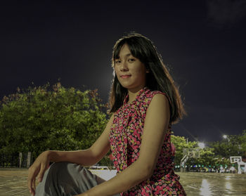 Side view of woman sitting against water