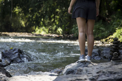 Low section of woman standing on rock