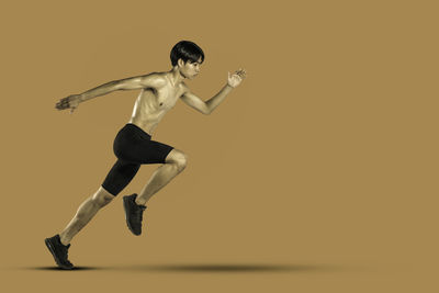 Full length of man running against gray background