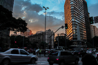 Traffic on city street and buildings at dusk