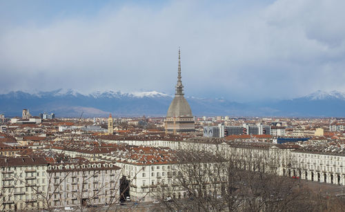 Buildings in city against cloudy sky