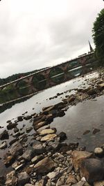 Rocks by river against sky