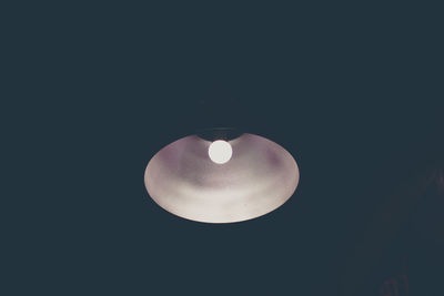 Low angle view of illuminated light bulb against black background