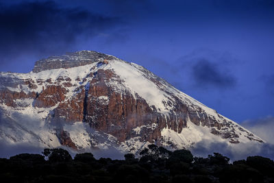 Low angle view of snowcapped mountain against sky