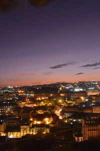 Illuminated cityscape against sky at night