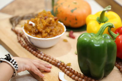 Close-up of woman holding vegetables on table