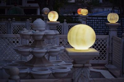 Close-up of illuminated lamp against building