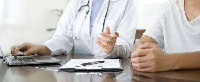 Midsection of doctor examining patient at clinic