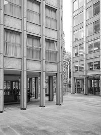 Empty road by buildings in city