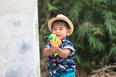 Portrait of cute boy holding hat