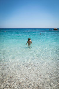 Man swimming in sea against clear sky