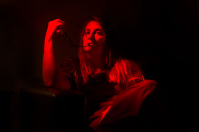 Portrait of mature woman sitting in illuminated room at home