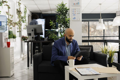 Side view of businessman using laptop at office
