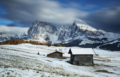 Snowy huts against snowcapped mountains