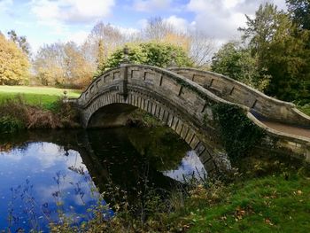 Arch bridge over lake against sky