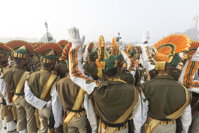 Rear view of marching band wearing uniforms on street