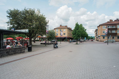 People on street in city against sky