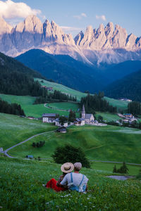 People relaxing on landscape against mountains