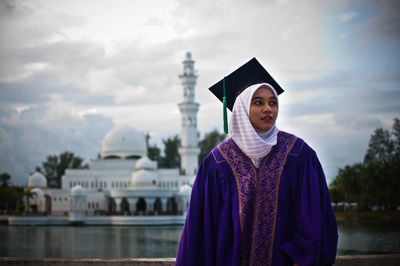 Portrait of mature man standing against built structure