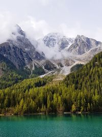 Scenic view of lake by mountains against sky