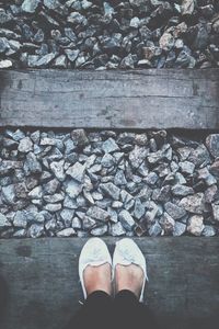 Low section of woman standing on railroad tie