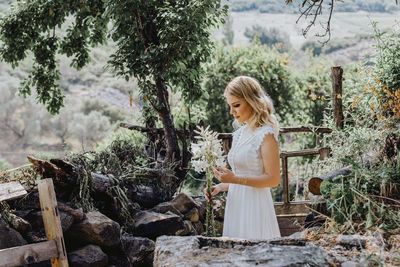 Woman standing by plants in forest