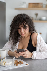 Young woman eating food at home