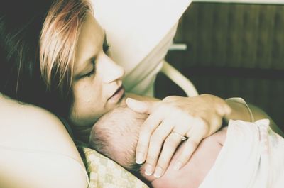 Close-up of woman sleeping with her newborn baby