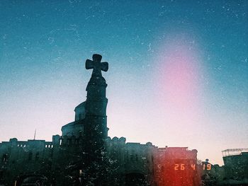 Low angle view of statue against illuminated buildings in city
