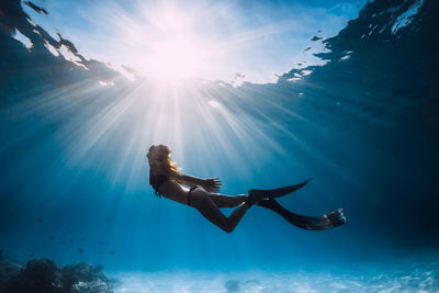 Rear view of woman swimming in sea