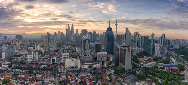 Aerial view of cityscape against cloudy sky