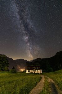 House on field against sky at night