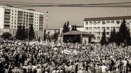 People on street against buildings in city