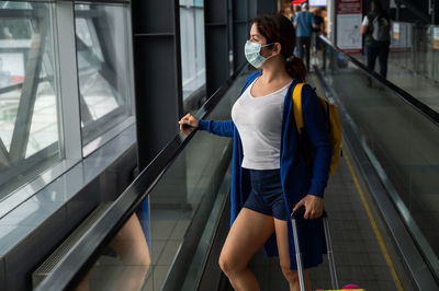 Woman standing on escalator