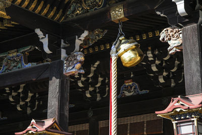 Low angle view of lanterns hanging on roof outside building