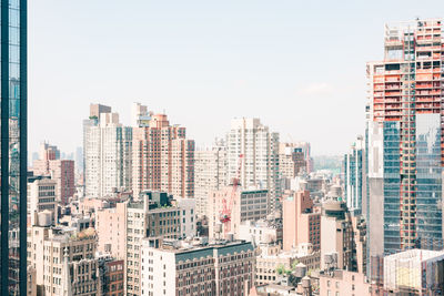 Buildings in city against clear sky