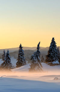 Scenic view of snow covered landscape against sky during sunset