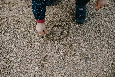 Low section of child standing on sand