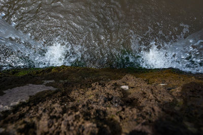 High angle view of waves breaking on rocks