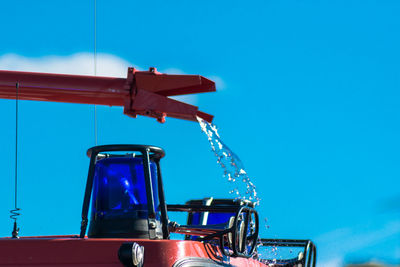 Close-up of red car against blue sky
