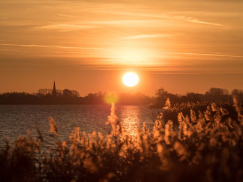 Scenic view of lake against sky during sunset