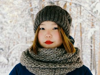 Portrait of woman wearing knit hat and woolen scarf during winter