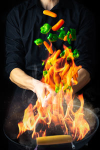 Chef with wok sauteing and flaming vegetables