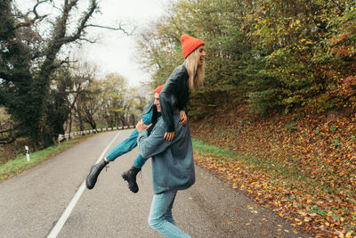 Young loving couple are fooling around outside.